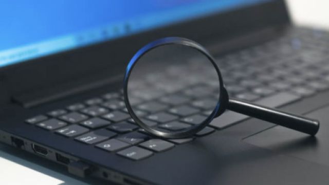 Lente di ingrandimento appoggiata sulla tastiera di un computer