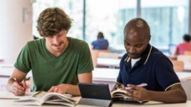 Due ragazzi seduti che studiano