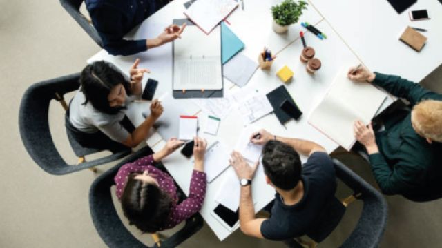 immagine con persone che lavorano intorno a un tavolo