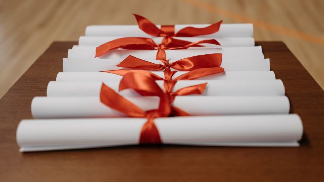 Pergamene di laurea arrotolate con un nastro rosso
