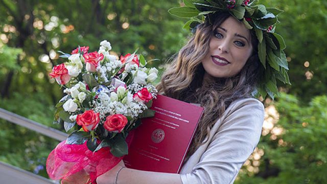Studentessa laureata con la tesi di laurea in mano