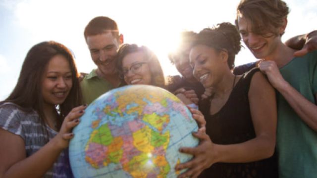ragazze e ragazzi che sorreggono un mappamondo