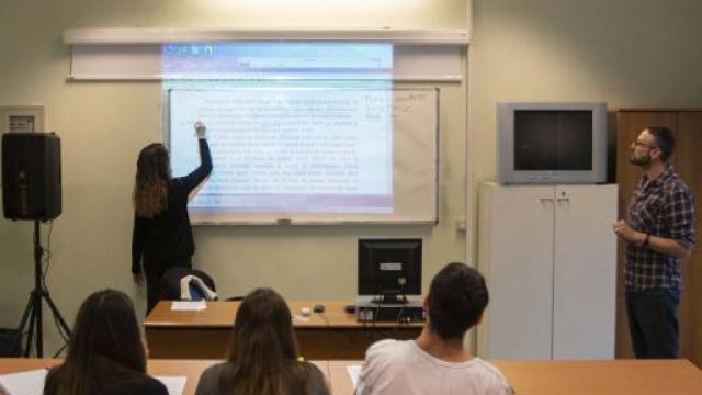 Lezione di un docente alla lavagna con gruppo di studenti
