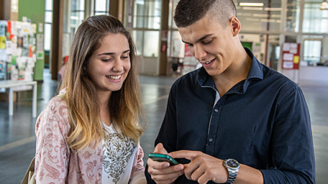 Bando per il progetto "Scuola dei compiti" Due giovani studenti consultano lo smartphone