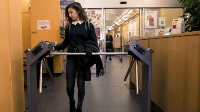 Studentessa che inserisce la sua tessera di riconoscimento per passare un ingresso bloccato