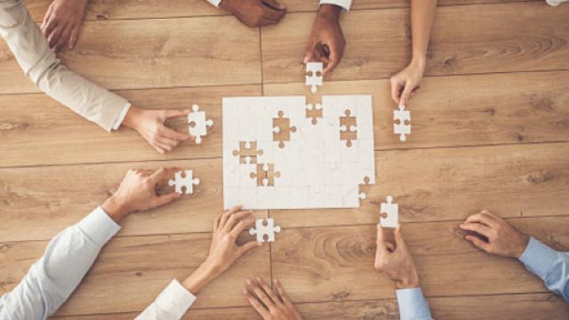 diverse mani che compongono un puzzle bianco