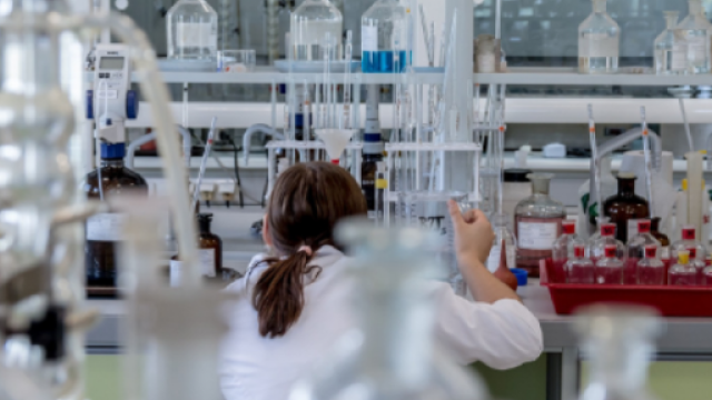 ricercatrice intenta a lavorare all'interno di un laboratorio chimico