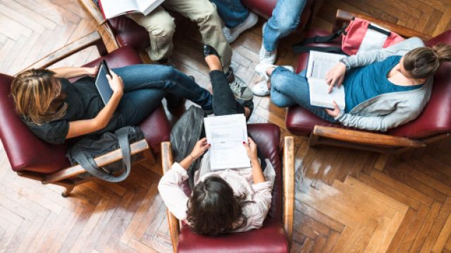 foto dall'alto di alcuni studenti seduti su delle poltroncine disposte in circolo