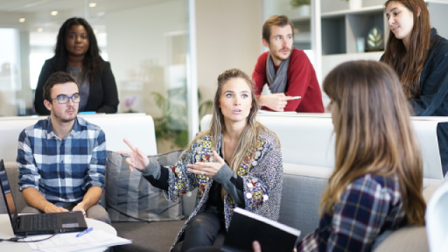 foto di 6 persone, ragazze e ragazzi, che dialogano, alcuni seduti, altri in piedi