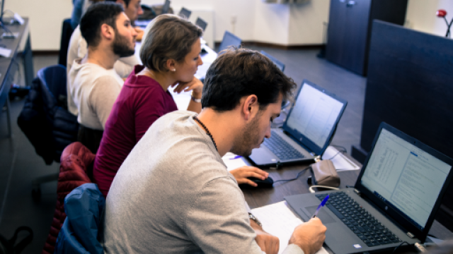 Studenti in aula seduti di fronte a un computer