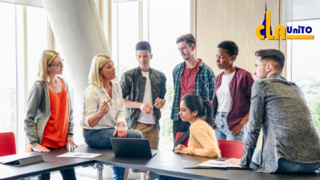 studenti ascoltano la lezione di una professoressa all'interno di un'aula