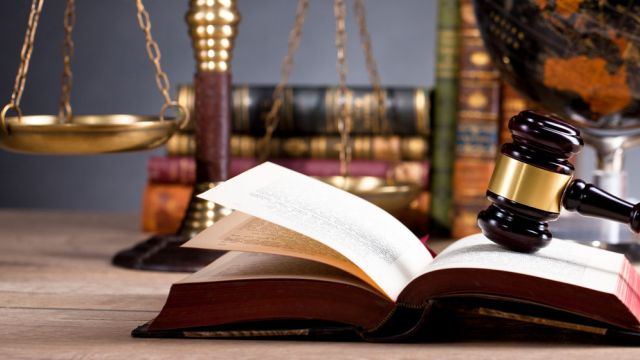 Oggetti che rappresentano la legge: codici, martello da giudice, bilancia a due piatti e mappamondo