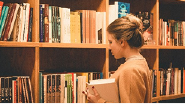 Una studentessa cerca un libro all'interno di una libreria