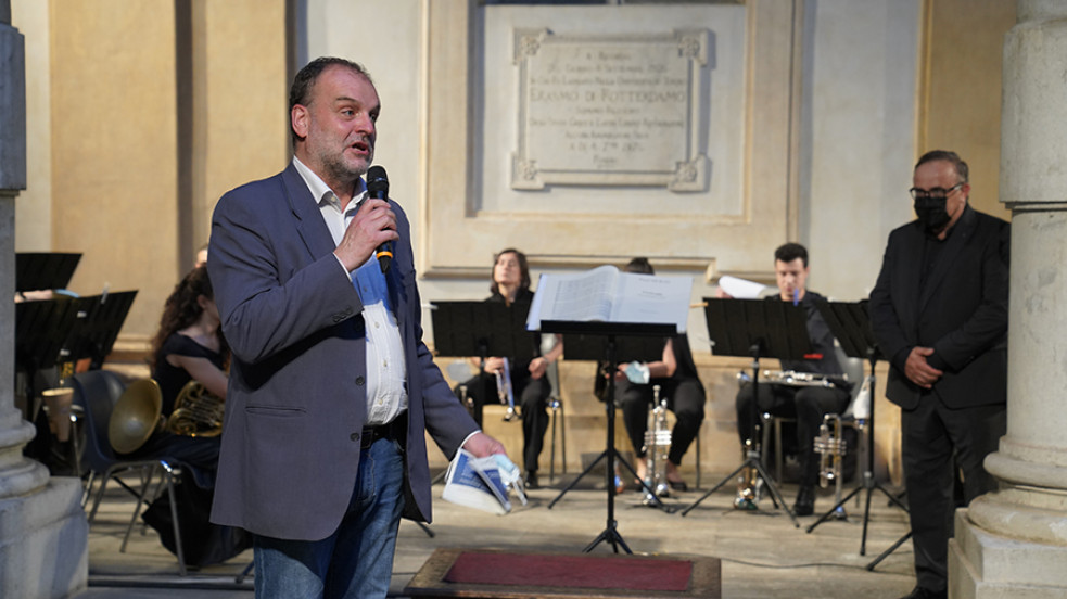 Il rettore Geuna parla al microfono davanti all'orchestra pronta a suonare