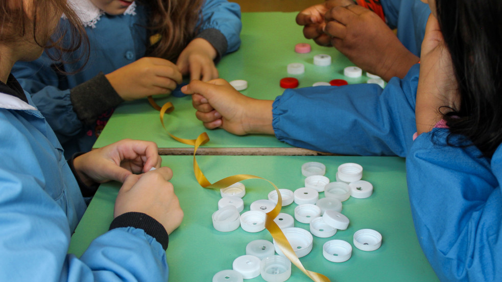 gruppo bambini che lavora con tappi di plastica