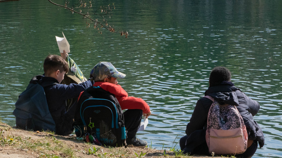 bambini seduti sulla riva di un fiume