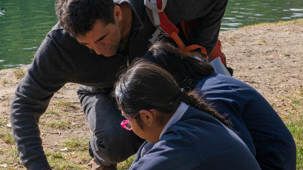 docente con bambine sulla riva di un fiume