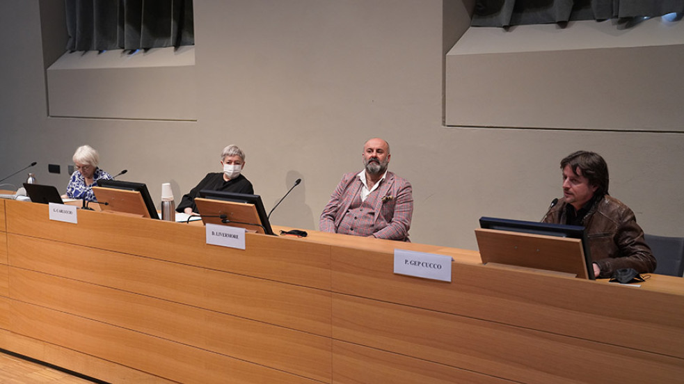 Relatori e relatrici di fronte al pubblico in aula magna