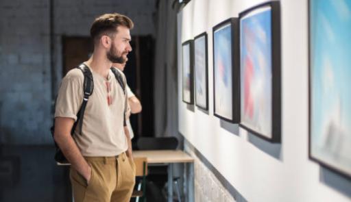 Ragazzo davanti a dei quadri appesi