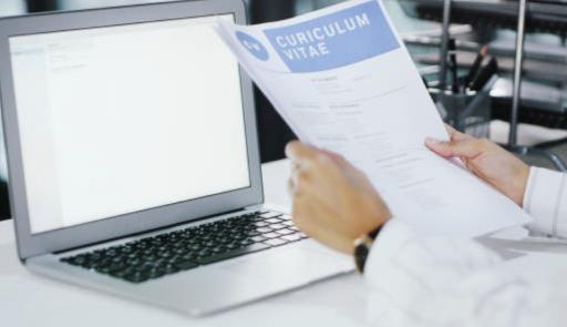 immagine con una persona che legge un cv davanti a pc