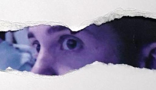 Sguardo di un uomo all'interno di uno strappo di carta