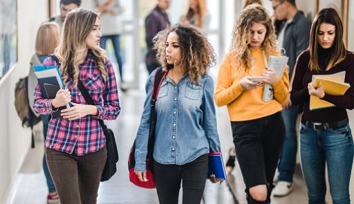 Studentesse chiacchierano camminando nella hall di un campus