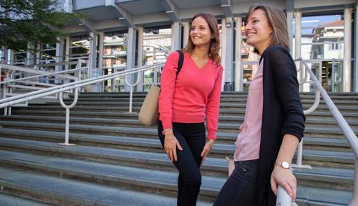 Due studentesse appoggiate al corrimano sulle scale di ingresso di Palazzo Nuovo