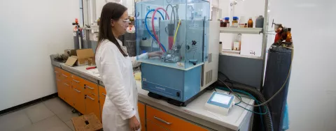 Una ricercatrice di fronte a uno strumento di laboratorio