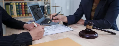 Due persone a una scrivania firmano un documento