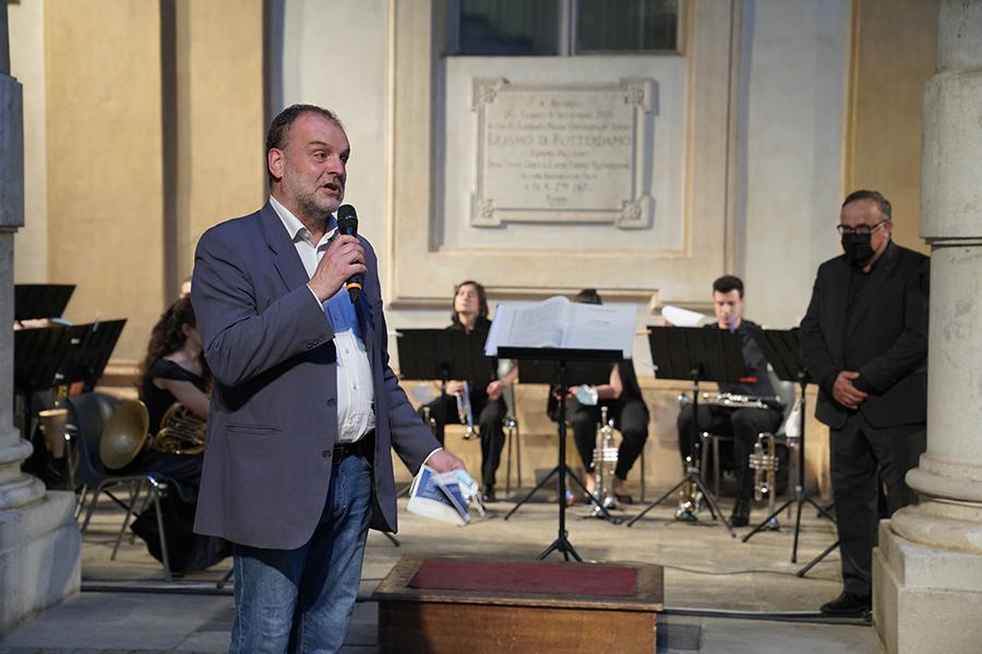 Il rettore Geuna parla al microfono davanti all'orchestra pronta a suonare