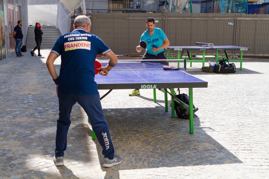 Due uomini intenti a giocare una partita a ping pong