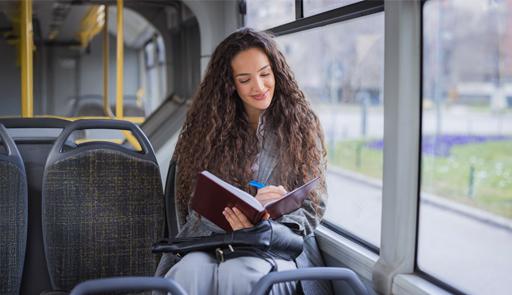 Ragazza seduta all'interno di un bus con un libro tra le mani