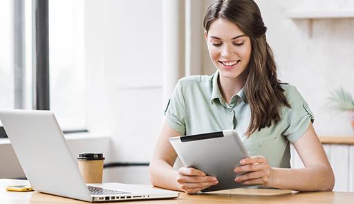 Studentessa alla scrivania con portatile e tablet