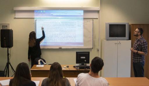 Insegnante che spiega alla lavagna e studenti che seguono la lezione