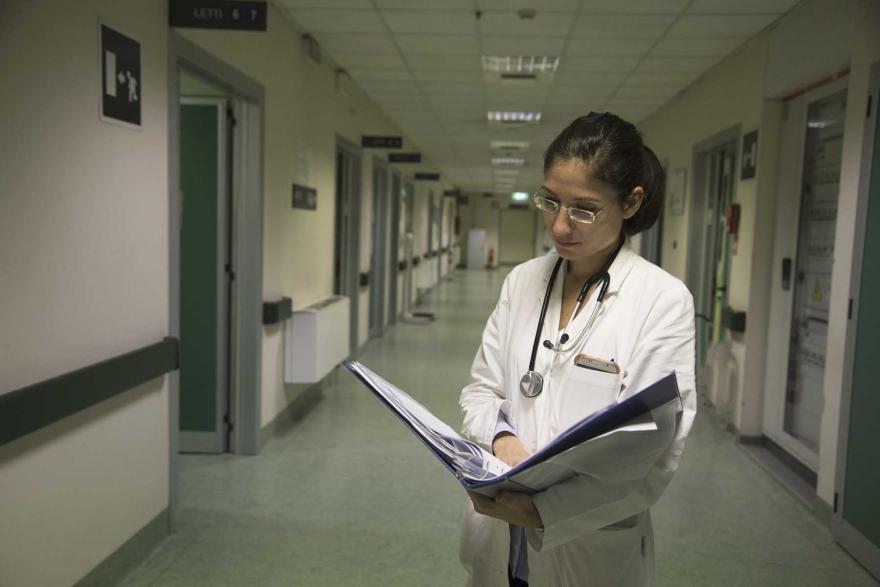 Dottoressa consulta delle carte in un corridoio dell'ospedale