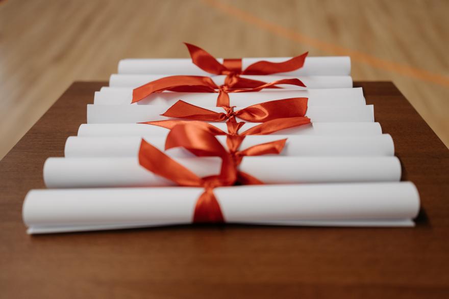 Pergamene di laurea arrotolate con un nastro rosso