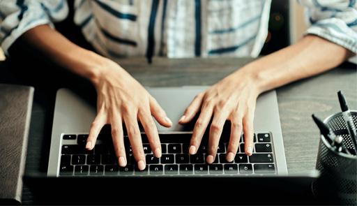 Mani di uno studente poggiate sulla tastiera di un pc portatile