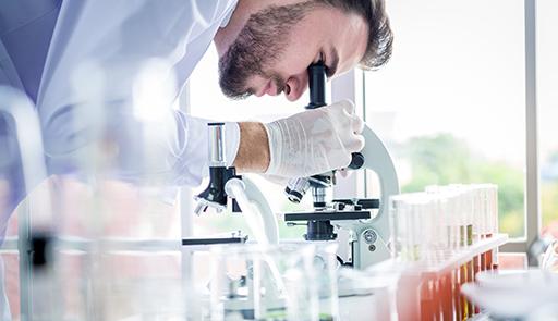 Ricercatore al microscopio all'interno di un laboratorio
