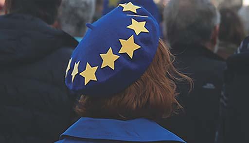 Donna di spalle con cappello blu e stelle gialle (bandiera europea)
