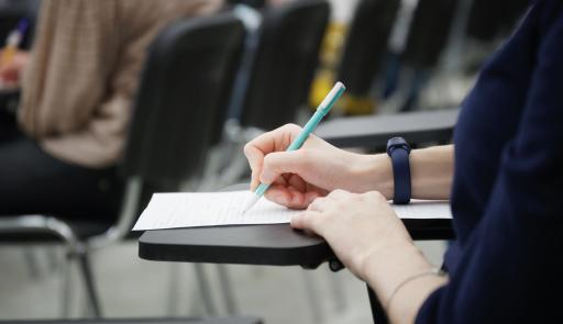 Mano femminile che scrive su un foglio