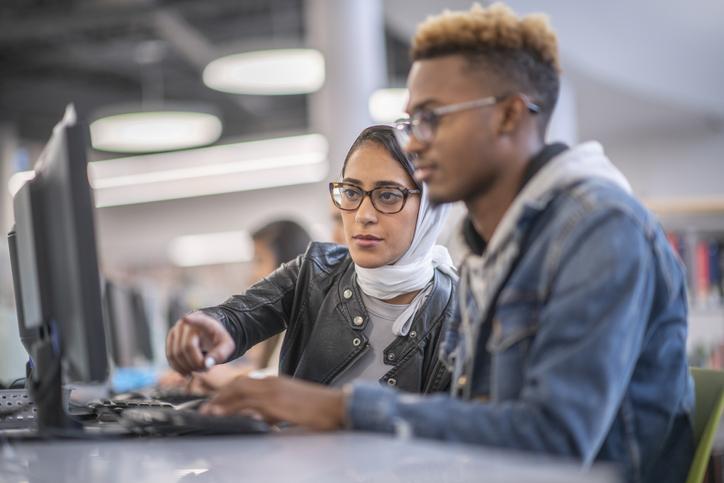 Studentessa afgana al computer con un altro studente