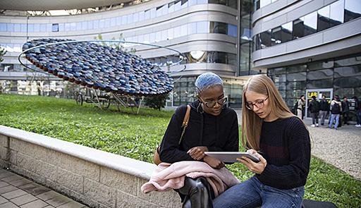 CLE esterno - Due studentesse sedute guardano un tablet