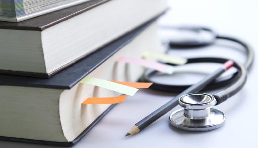 immagine con libri, matita e stetoscopio