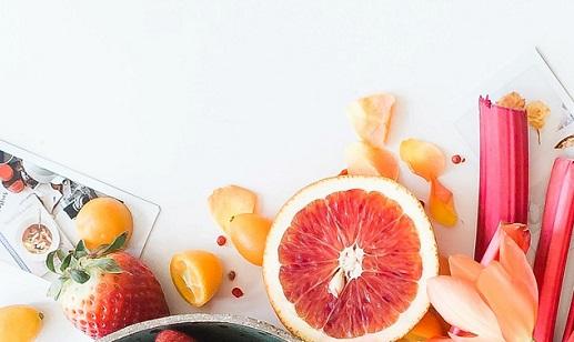 foto di un'arancia tagliata a fette e altri frutti e fiori