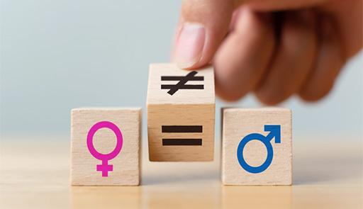 mano che gioca con tre dadi di legno sui quali sono presenti tre simboli: genere femmine, uguale, genere maschile