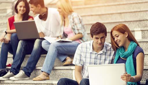 Studenti seduti sulle scale che guardano il computer 