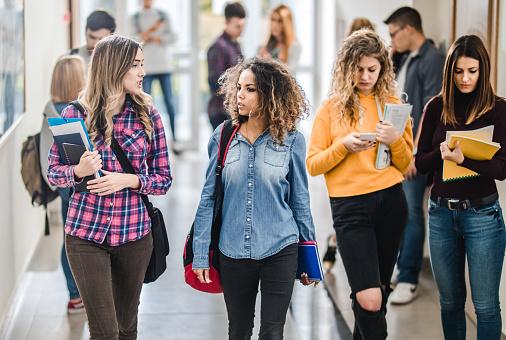 Studentesse chiacchierano camminando nella hall di un campus