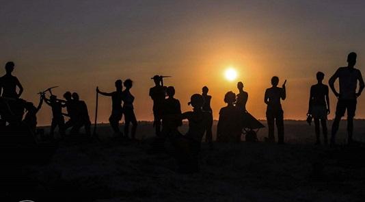 Presentazione della Scuola di specializzazione in Beni archeologici Giorgio Gullini figure maschili e femminili in controluce, sullo sfondo il sole che sorge