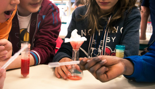 Bambine e bambini all'università Bambini e bambine con provette per esperimenti