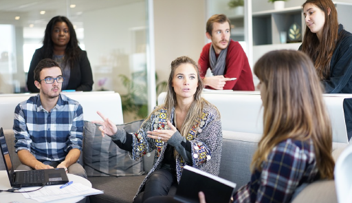 foto di 6 persone, ragazze e ragazzi, che dialogano, alcuni seduti, altri in piedi